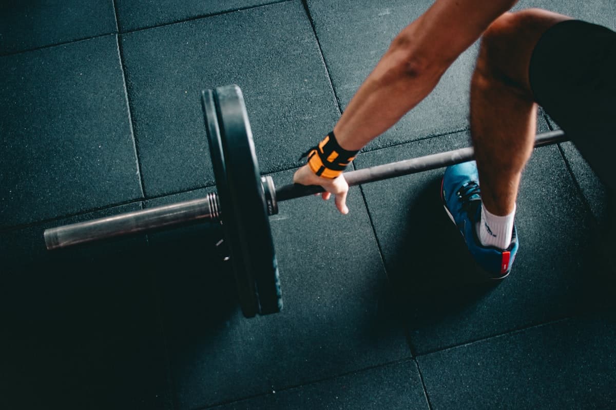 Athlete gripping a loaded barbell on a gym floor